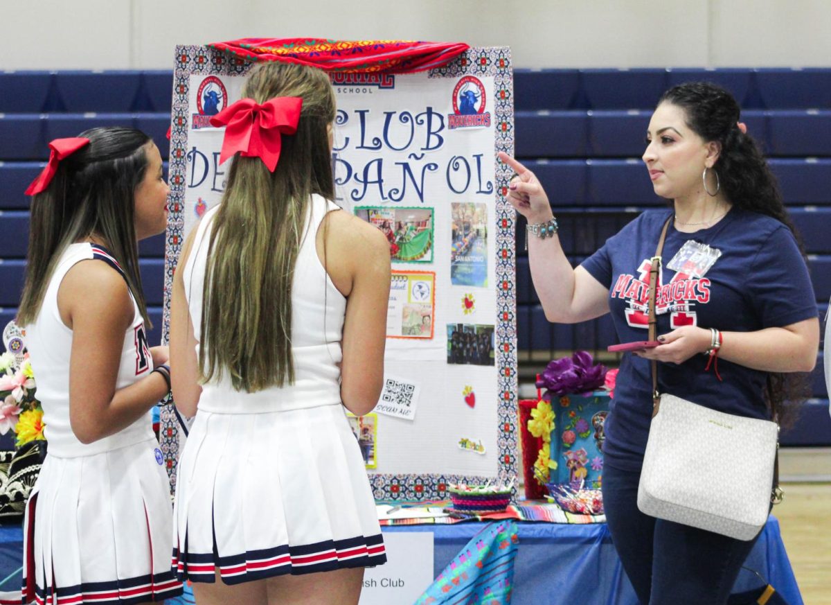 Rosa Gonzalez talks to students at a Bull School booth about joining Spanish Club. 