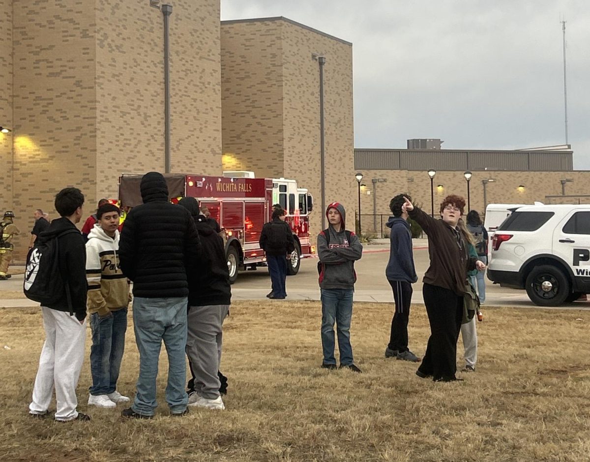 Students wait outside Memorial High School Tuesday morning after a fire occurred in the SPED area. 